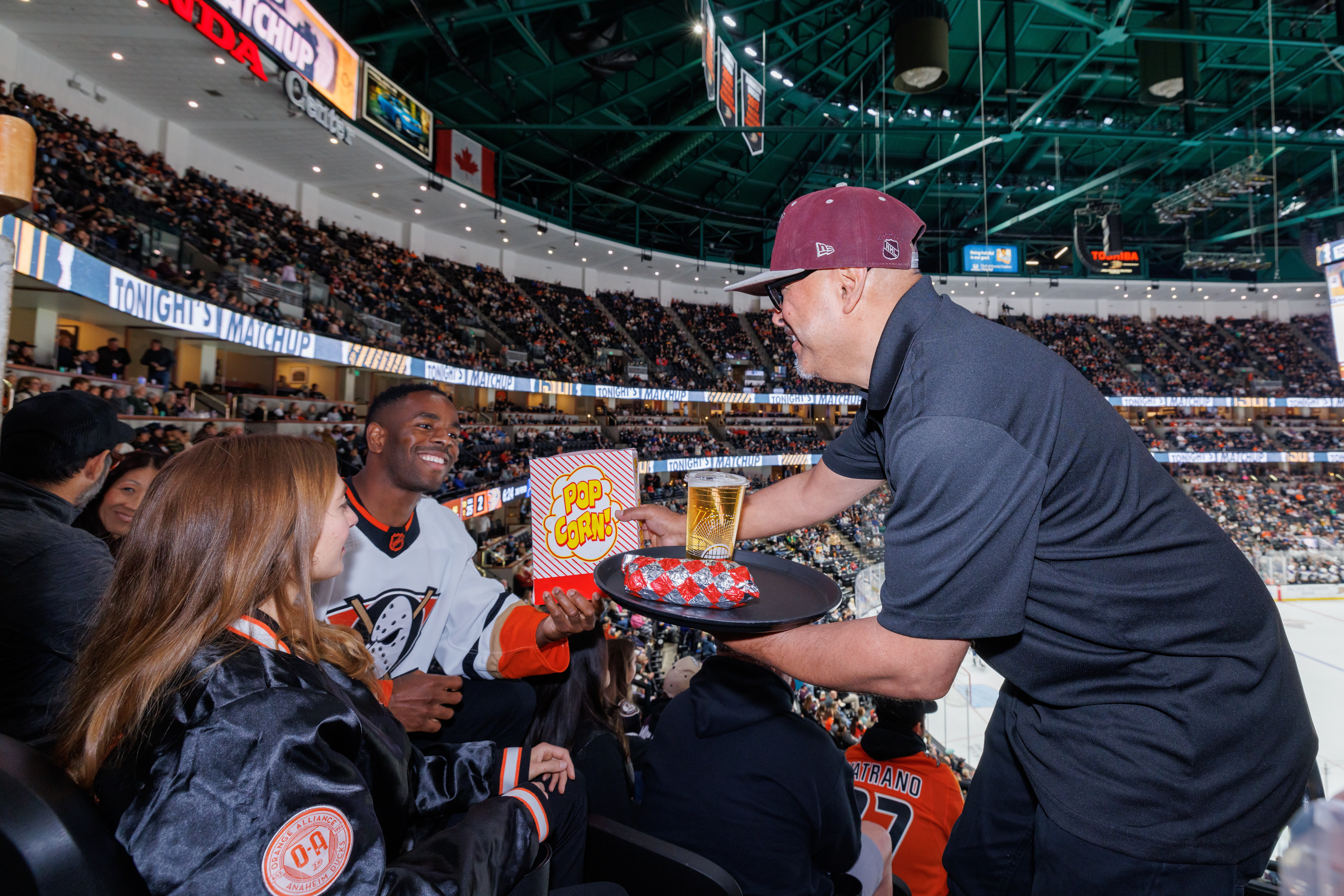 A Honda Center staff member delivers food to a Club Seat Member.